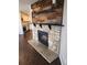 Cozy living space highlighting a rustic stone fireplace and decorative wood mantle, adjacent to a modern kitchen at 185 S Sable Blvd # T18, Aurora, CO 80012