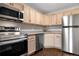 This spacious kitchen has stainless steel appliances, light wood cabinets, and lovely countertops at 185 S Sable Blvd # T18, Aurora, CO 80012
