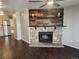 Open living room with wood floors, a modern ceiling fan and a charming stone fireplace at 185 S Sable Blvd # T18, Aurora, CO 80012