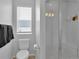 Well-lit bathroom with a toilet, window, and a modern glass-enclosed shower at 18938 E 64Th Pl, Denver, CO 80249