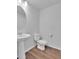 Clean bathroom with a pedestal sink, toilet, and hardwood floors at 18938 E 64Th Pl, Denver, CO 80249