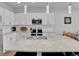 Spacious kitchen featuring white cabinets, stainless steel appliances, and a granite island at 18938 E 64Th Pl, Denver, CO 80249