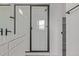 Bathroom featuring tiled shower with a glass door, dual vanity, and modern hardware at 20520 E 58Th Ave, Aurora, CO 80019