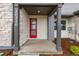 Inviting front porch featuring a red door and stone pillar accents at 20520 E 58Th Ave, Aurora, CO 80019