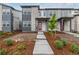 Welcoming entrance to a modern townhome featuring stone accents and a bright red door at 20520 E 58Th Ave, Aurora, CO 80019