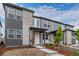 Inviting entryway to this modern townhome with stylish stonework and a vibrant red door at 20520 E 58Th Ave, Aurora, CO 80019