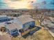 Aerial view of a blue townhome, fenced yard, and surrounding neighborhood at sunset at 7946 Chase Cir # 112, Arvada, CO 80003