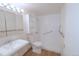 Bright bathroom featuring white tile, storage shelves, grab bars, and a sink at 799 Dahlia St # 201, Denver, CO 80220