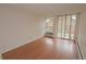 Bedroom featuring sliding glass doors to balcony, neutral paint and hardwood floor at 799 Dahlia St # 201, Denver, CO 80220