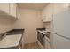 Kitchen featuring white appliances, white cabinets and grey countertop at 799 Dahlia St # 201, Denver, CO 80220