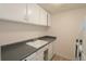 Kitchen featuring white appliances, white cabinets and grey countertop at 799 Dahlia St # 201, Denver, CO 80220