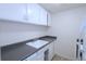 Small kitchen with white cabinets, a grey countertop, and a stainless steel sink at 799 Dahlia St # 201, Denver, CO 80220
