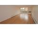 Living room featuring sliding glass doors to balcony, neutral paint and hardwood floor at 799 Dahlia St # 201, Denver, CO 80220