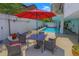 Outdoor community pool with lounge chairs and table under a red umbrella at 799 Dahlia St # 201, Denver, CO 80220