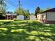 Spacious backyard with green lawn, storage sheds, and potential for outdoor activities at 2124 S Yates St, Denver, CO 80219