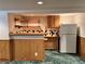 Basement bar with wood paneling, a refrigerator and ample storage space at 2124 S Yates St, Denver, CO 80219