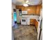 Functional kitchen with white appliances, oak cabinetry, and linoleum floors at 2124 S Yates St, Denver, CO 80219