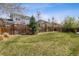 Expansive backyard with lush grass, a wooden fence, and mature trees providing privacy at 2794 Lima St, Denver, CO 80238