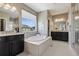 Main bathroom with a soaking tub, double vanity, and shower, offering a luxurious and functional space at 2794 Lima St, Denver, CO 80238
