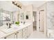 Elegant bathroom with double vanity, marble tile, and soaking tub at 6716 W 97Th Cir, Broomfield, CO 80021