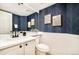 Stylish powder room with navy chevron wallpaper and white vanity at 6716 W 97Th Cir, Broomfield, CO 80021