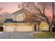 Two-story house with beige siding, three-car garage, and landscaping at 6716 W 97Th Cir, Broomfield, CO 80021