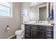 Well-lit bathroom featuring a dark vanity, white countertop, and modern fixtures at 211 Luna Ct, Erie, CO 80516