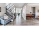 Elegant foyer with staircase, seating, and wood floors leading to the living room at 211 Luna Ct, Erie, CO 80516