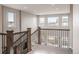 Bright, spacious staircase landing with wooden railings and scenic neighborhood views at 211 Luna Ct, Erie, CO 80516