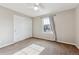 Bedroom with neutral carpet, white walls, ceiling fan, closet, and a window with neighborhood views at 9957 Candlewood Ln, Highlands Ranch, CO 80126