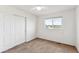 Bedroom with neutral carpet, white walls, ceiling fan, closet, and a window with neighborhood views at 9957 Candlewood Ln, Highlands Ranch, CO 80126