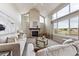 Bright living room featuring a brick fireplace, high ceilings, and large windows with scenic views at 9957 Candlewood Ln, Highlands Ranch, CO 80126