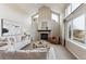 Bright living room featuring a brick fireplace, high ceilings, and large windows with scenic views at 9957 Candlewood Ln, Highlands Ranch, CO 80126
