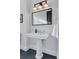 Elegant bathroom with pedestal sink, modern lighting, and a large mirror at 1312 Jade Ln, Longmont, CO 80504