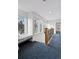 Upper hallway with window seat, carpet, and an iron railing at 1312 Jade Ln, Longmont, CO 80504