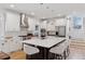 Modern kitchen with white cabinets, stainless steel appliances, and a large island with seating at 1312 Jade Ln, Longmont, CO 80504