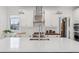 Modern kitchen with white cabinets, stainless steel appliances, and large island at 1312 Jade Ln, Longmont, CO 80504