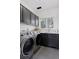 Bright laundry room with modern washer, dryer, and dark cabinetry at 1312 Jade Ln, Longmont, CO 80504