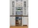 Built-in wet bar with glass-front cabinets and beverage cooler at 1312 Jade Ln, Longmont, CO 80504