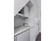 Small wet bar with a sink, mini-fridge, and white cabinets at 1312 Jade Ln, Longmont, CO 80504