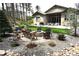 Landscaped backyard oasis with a fire pit, waterfall feature, and mature trees at 878 Tree Bark Ter, Colorado Springs, CO 80132
