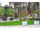 Outdoor space with waterfall feature, a fire pit, and mature landscaping on a lush lot at 878 Tree Bark Ter, Colorado Springs, CO 80132