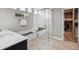 Bright bathroom with tiled walk-in shower, black vanity, and access to the walk-in closet at 878 Tree Bark Ter, Colorado Springs, CO 80132