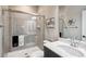 Modern bathroom featuring a glass-enclosed shower, gray tiled walls, and a stylish vanity with sleek fixtures at 878 Tree Bark Ter, Colorado Springs, CO 80132