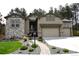 Charming home featuring a three-car garage and beautifully landscaped front yard at 878 Tree Bark Ter, Colorado Springs, CO 80132