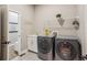 Functional laundry room with modern washer and dryer units, sink, and storage space at 878 Tree Bark Ter, Colorado Springs, CO 80132
