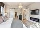 Stylish primary bedroom with fireplace, barn door to the walk-in closet, and chandelier lighting at 878 Tree Bark Ter, Colorado Springs, CO 80132