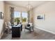 Well-lit home office space with large windows, plush carpet, and stylish light fixture at 878 Tree Bark Ter, Colorado Springs, CO 80132