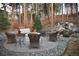 Outdoor firepit with seating area, surrounded by mature trees and a wooden fence at 878 Tree Bark Ter, Colorado Springs, CO 80132