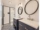 Bathroom featuring double vanity, black framed shower, and decorative tile floor at 5843 S Danube St, Aurora, CO 80015